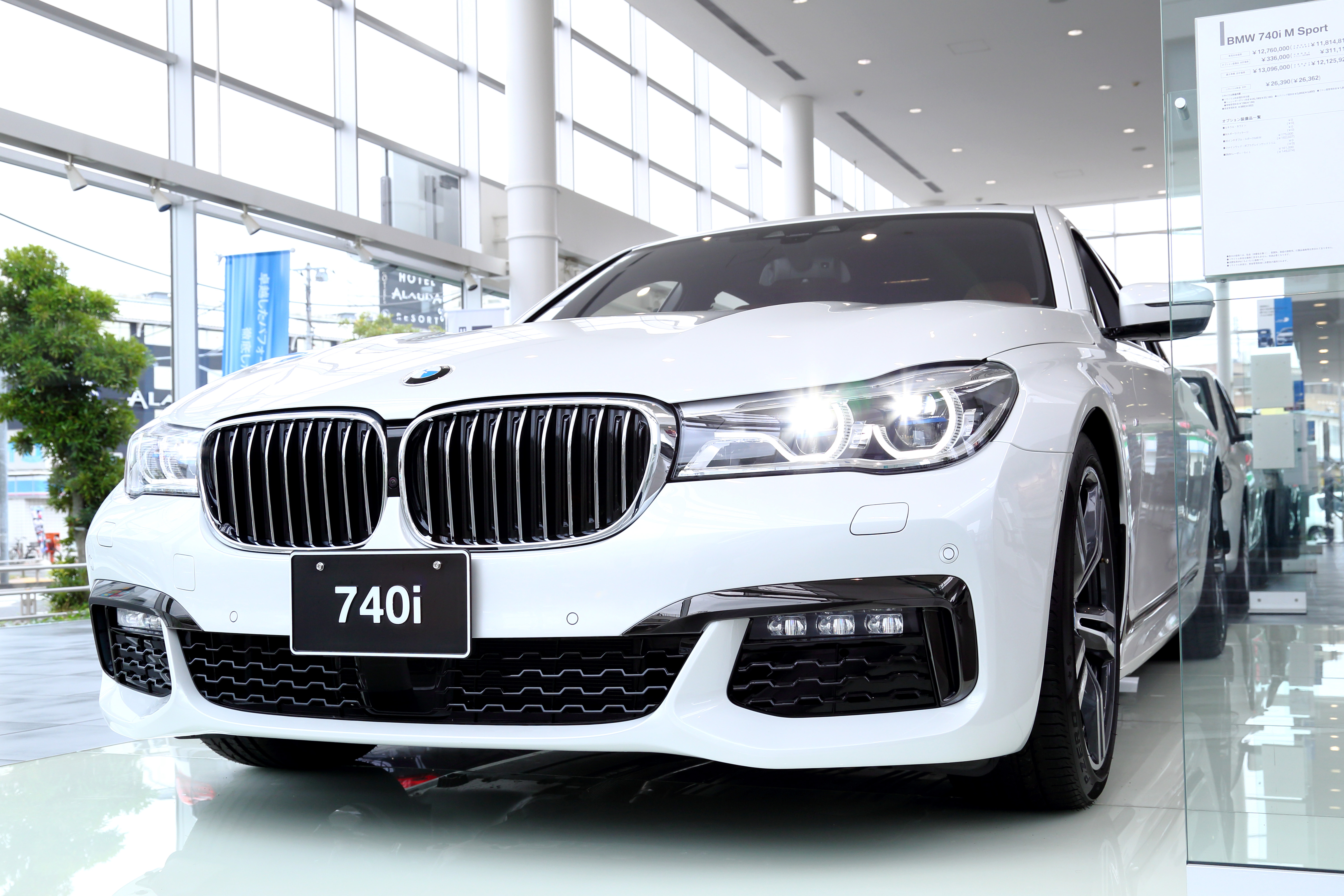 주차된 흰색 BMW 7시리즈 G11 M 스포츠 세단의 앞쪽과 오른쪽 측면