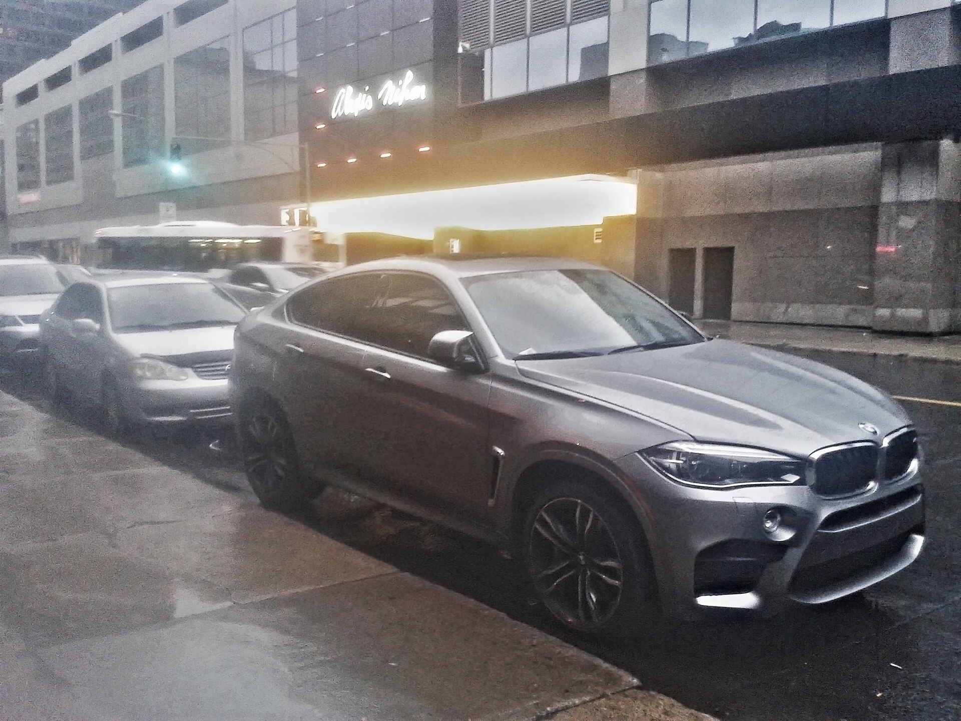 도로변에 주차된 흰색 BMW X6 F16의 앞쪽과 왼쪽 측면