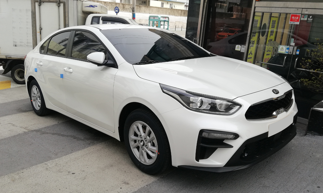 서울 도로에 세워진 흰색 기아 K3 BD의 앞쪽과 왼쪽 측면